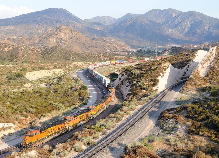 Der BNSF Containerzug schlängelt sich von San Bernardino her den Cajon  Pass
hinauf. Interessant sind die beiden alten SD40-2 hinter der Warbonnet GP60M, die...