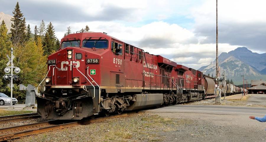 Eine ES44AC und eine AC4400CW ziehen den Getreidezug über den Bahnübergang, der
sich am oberen Ende des Bahnhofs von Banff befindet..  ----- © Markus Amport,...